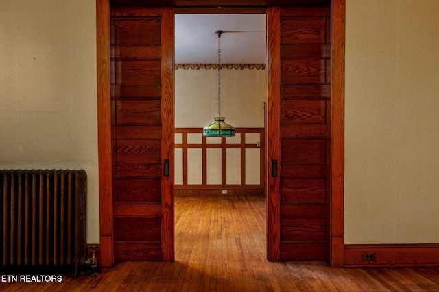 corridor featuring hardwood / wood-style flooring and radiator