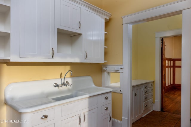 kitchen featuring white cabinetry and dark tile patterned flooring