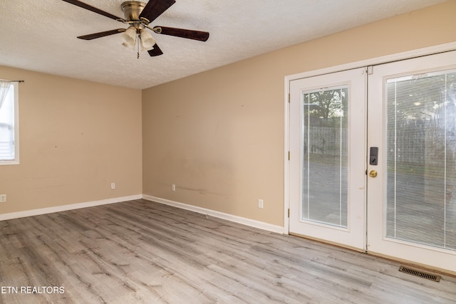 spare room featuring french doors, ceiling fan, a textured ceiling, and light hardwood / wood-style flooring