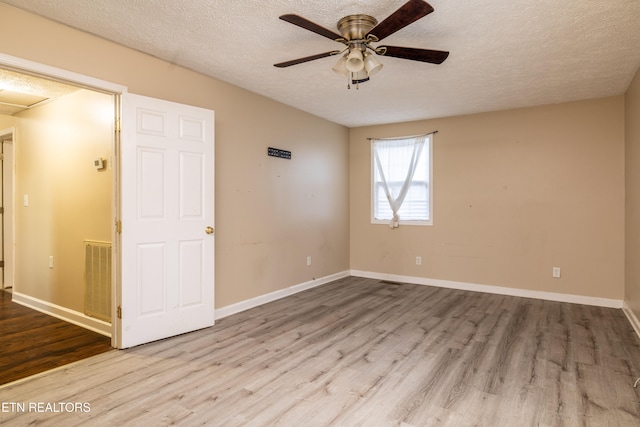 spare room with light hardwood / wood-style floors, a textured ceiling, and ceiling fan