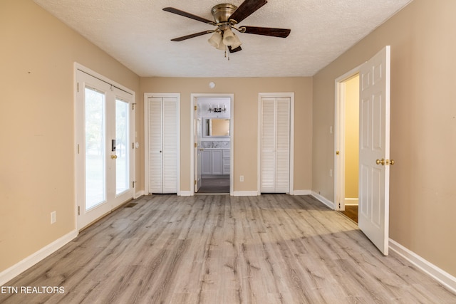 unfurnished bedroom featuring light hardwood / wood-style flooring, a textured ceiling, and ceiling fan