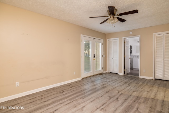 unfurnished bedroom featuring ensuite bathroom, a textured ceiling, light hardwood / wood-style floors, and ceiling fan