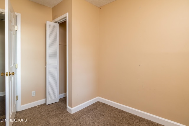 unfurnished bedroom with carpet and a textured ceiling