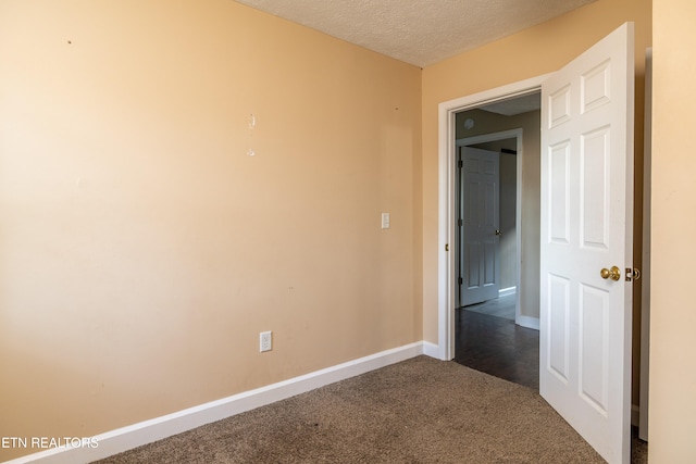 spare room featuring carpet and a textured ceiling