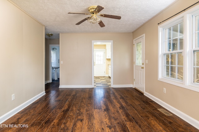 empty room featuring dark wood-type flooring, a textured ceiling, and ceiling fan