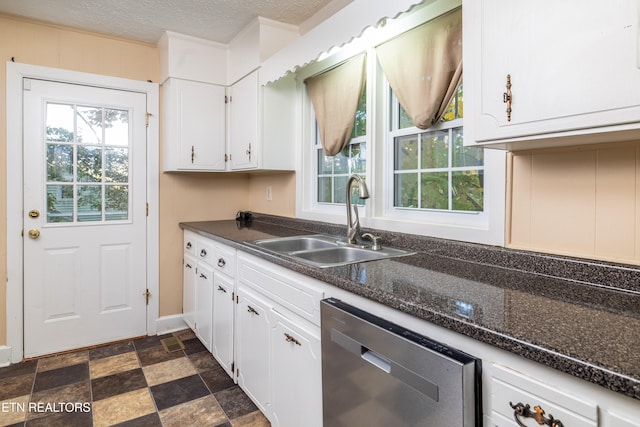 kitchen with white cabinets, stainless steel dishwasher, sink, and a textured ceiling