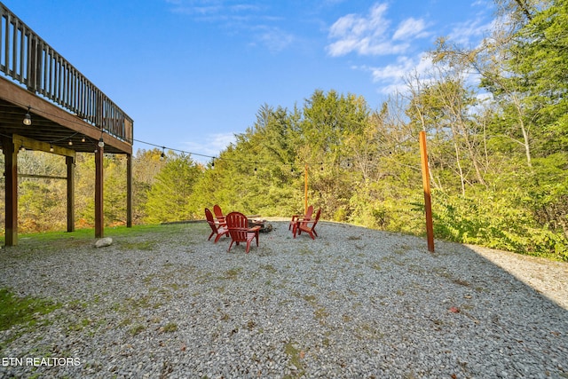 view of yard featuring a wooden deck, an outdoor fire pit, and a patio area