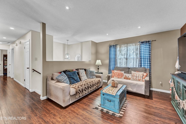 living room with a textured ceiling and dark hardwood / wood-style flooring