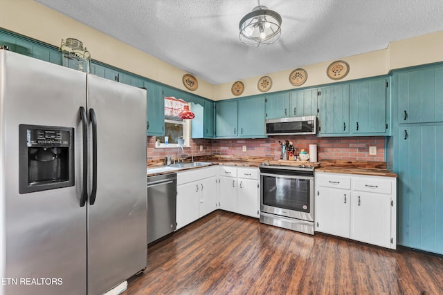 kitchen with decorative backsplash, appliances with stainless steel finishes, dark hardwood / wood-style floors, and a textured ceiling