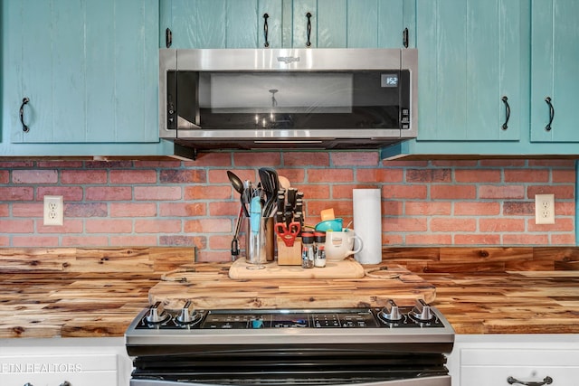 kitchen featuring wooden counters, appliances with stainless steel finishes, and backsplash