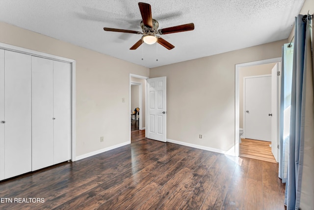 unfurnished bedroom with dark hardwood / wood-style flooring, a textured ceiling, and ceiling fan