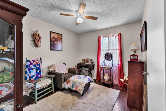 interior space featuring a textured ceiling, dark wood-type flooring, and ceiling fan