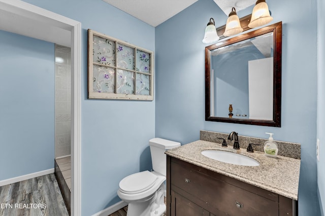 bathroom featuring vanity, hardwood / wood-style floors, toilet, and a shower