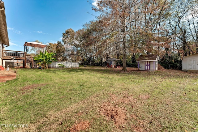 view of yard featuring a wooden deck and a storage shed