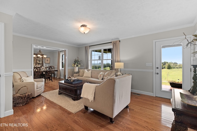 living room with hardwood / wood-style flooring, ornamental molding, and plenty of natural light