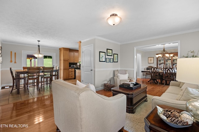 living room with crown molding, hardwood / wood-style floors, and a chandelier