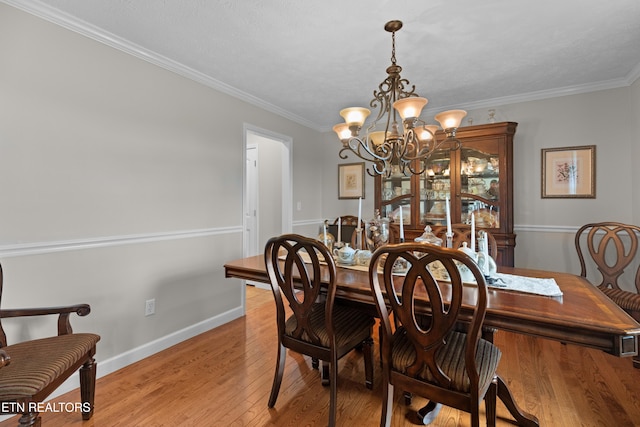 dining room featuring light hardwood / wood-style floors, a notable chandelier, and ornamental molding