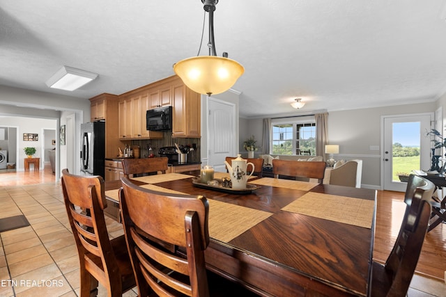 tiled dining area with crown molding, a textured ceiling, and plenty of natural light