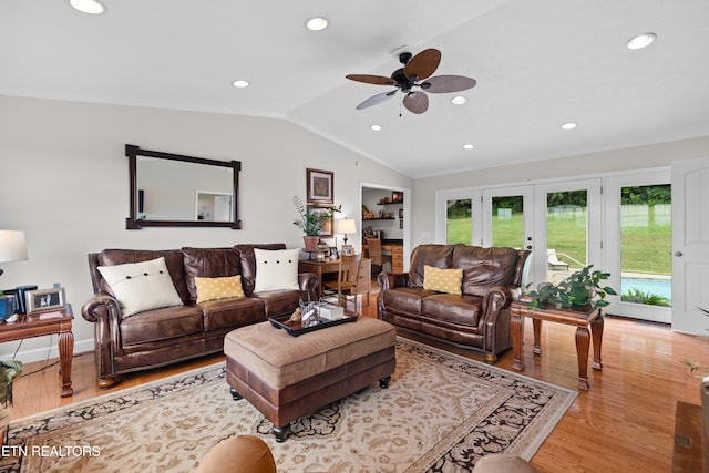 living room with lofted ceiling, ceiling fan, light wood-type flooring, crown molding, and french doors