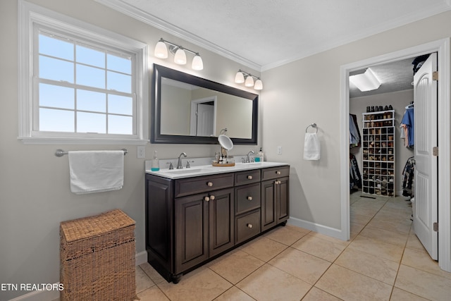 bathroom with vanity, a textured ceiling, ornamental molding, and tile patterned floors