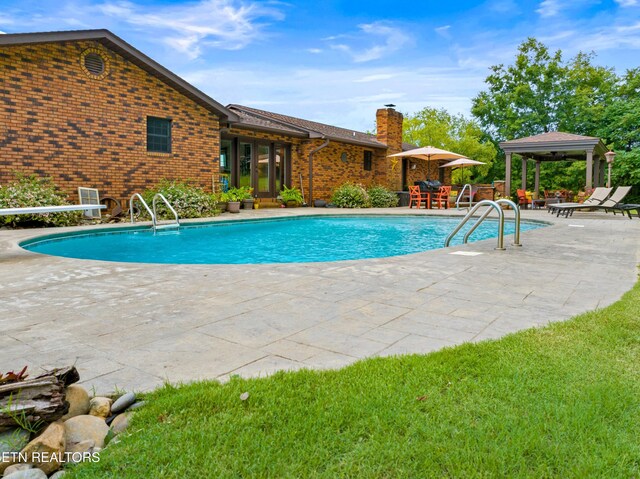 view of swimming pool with a patio and a gazebo