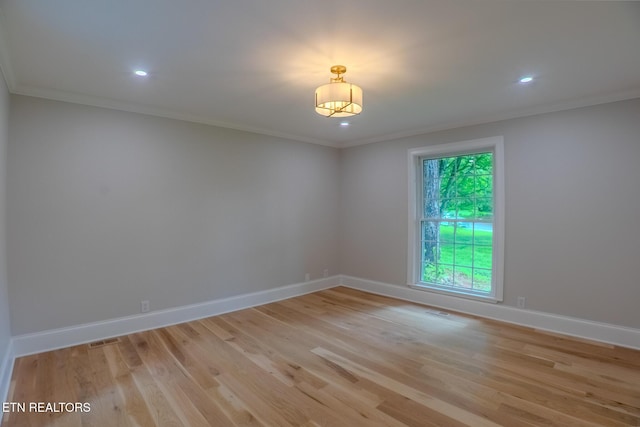 spare room with ornamental molding, baseboards, light wood finished floors, and recessed lighting