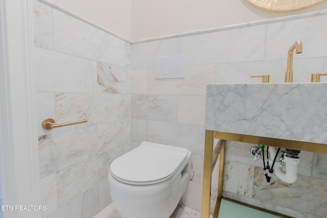 bathroom with tile walls and toilet