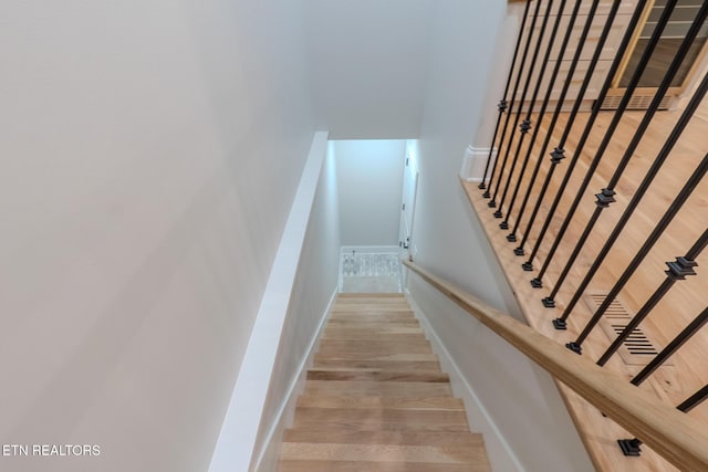 stairs featuring wood finished floors and baseboards