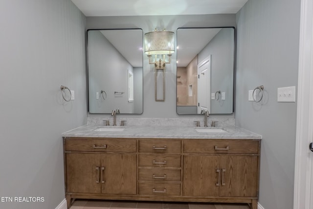 full bathroom featuring baseboards, double vanity, and tile patterned flooring