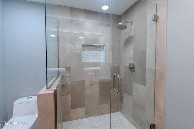 bathroom featuring toilet and a stall shower