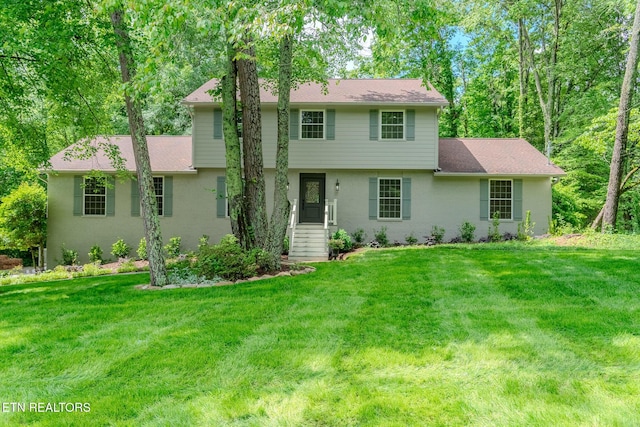 colonial home with a front yard and stucco siding