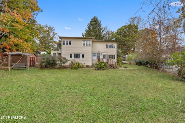 back of property with a storage shed and a yard