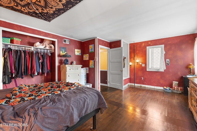 bedroom with dark wood-type flooring and a closet