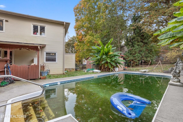 view of swimming pool with a diving board