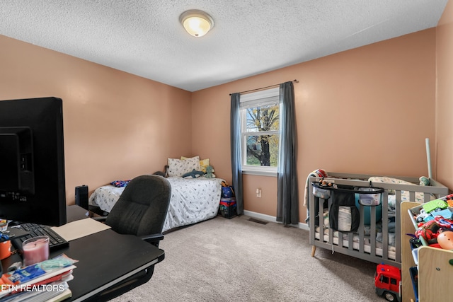 bedroom with carpet floors and a textured ceiling