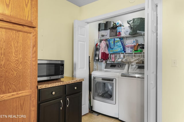 laundry area with washing machine and dryer and light tile patterned flooring