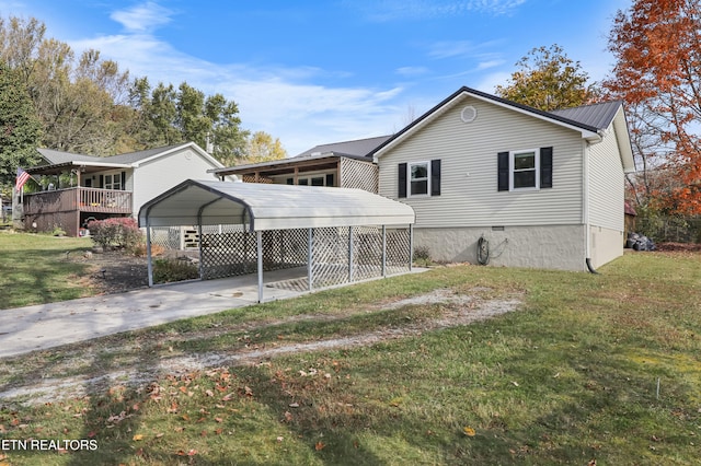 rear view of property with a deck, a lawn, and a carport