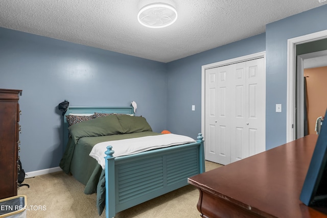 carpeted bedroom featuring a closet and a textured ceiling