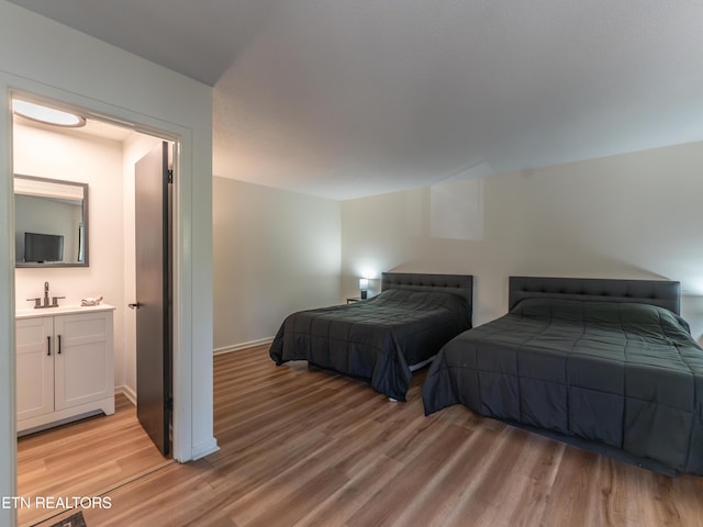 bedroom with light hardwood / wood-style floors and sink