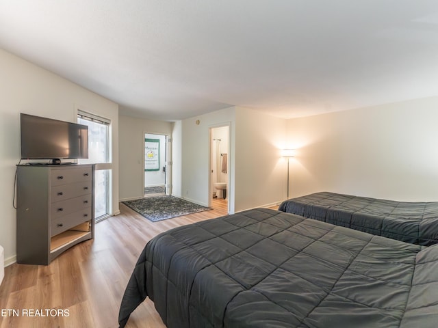 bedroom featuring ensuite bathroom and light hardwood / wood-style floors