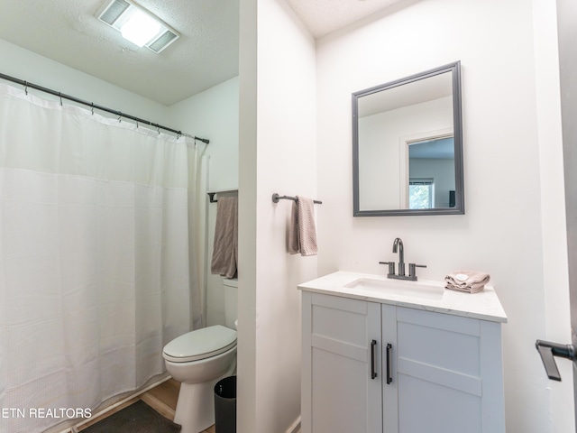 bathroom featuring vanity, toilet, a textured ceiling, and walk in shower