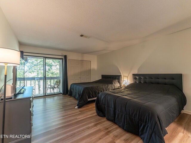 bedroom featuring a closet, wood-type flooring, and access to exterior