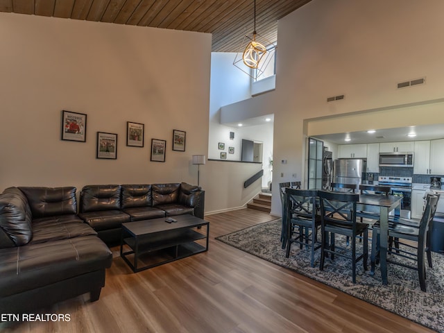 living room with hardwood / wood-style flooring, high vaulted ceiling, and wooden ceiling