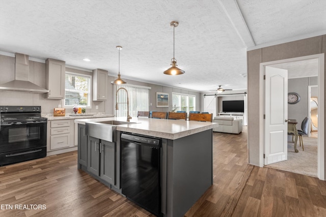 kitchen featuring wall chimney exhaust hood, a textured ceiling, black appliances, and gray cabinetry