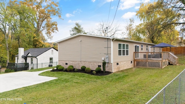 rear view of property with a yard and a deck