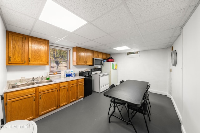 kitchen with white appliances, a paneled ceiling, and sink