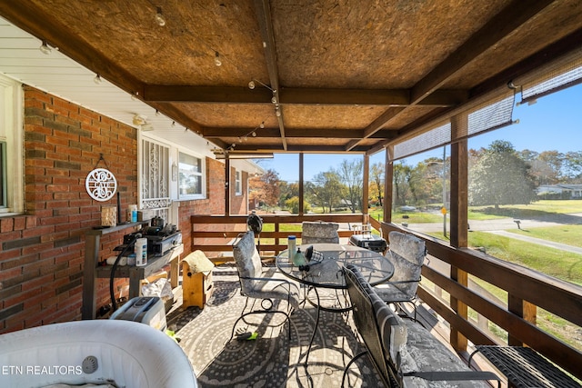 sunroom featuring beamed ceiling