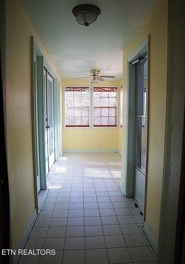 corridor featuring a barn door and light tile patterned floors