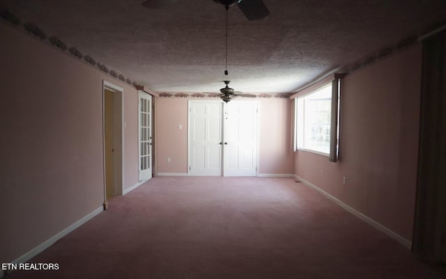 empty room with carpet floors, a textured ceiling, and ceiling fan