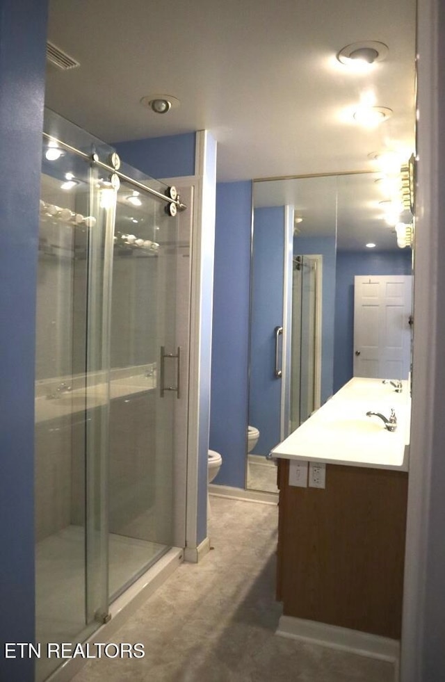 bathroom with vanity, toilet, and a shower with shower door